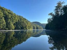Mirror-still Mill Creek Lake at sunrise with reflected forest