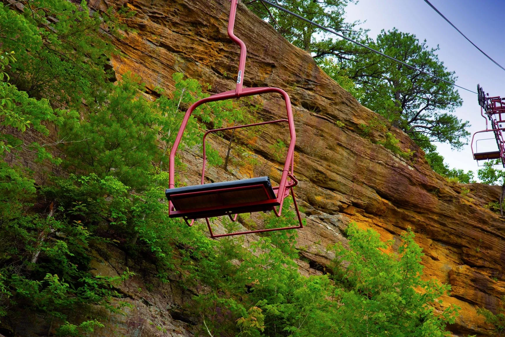 Red sky lift chair climbing the cliffside at Natural Bridge State Park