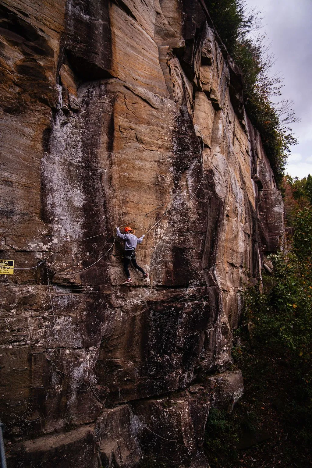 Climber on a sandstone wall on the via ferrata route in Kentucky