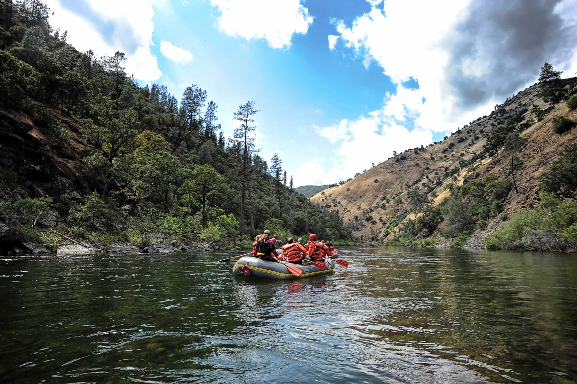 Raft drifting through a green Kentucky river canyon