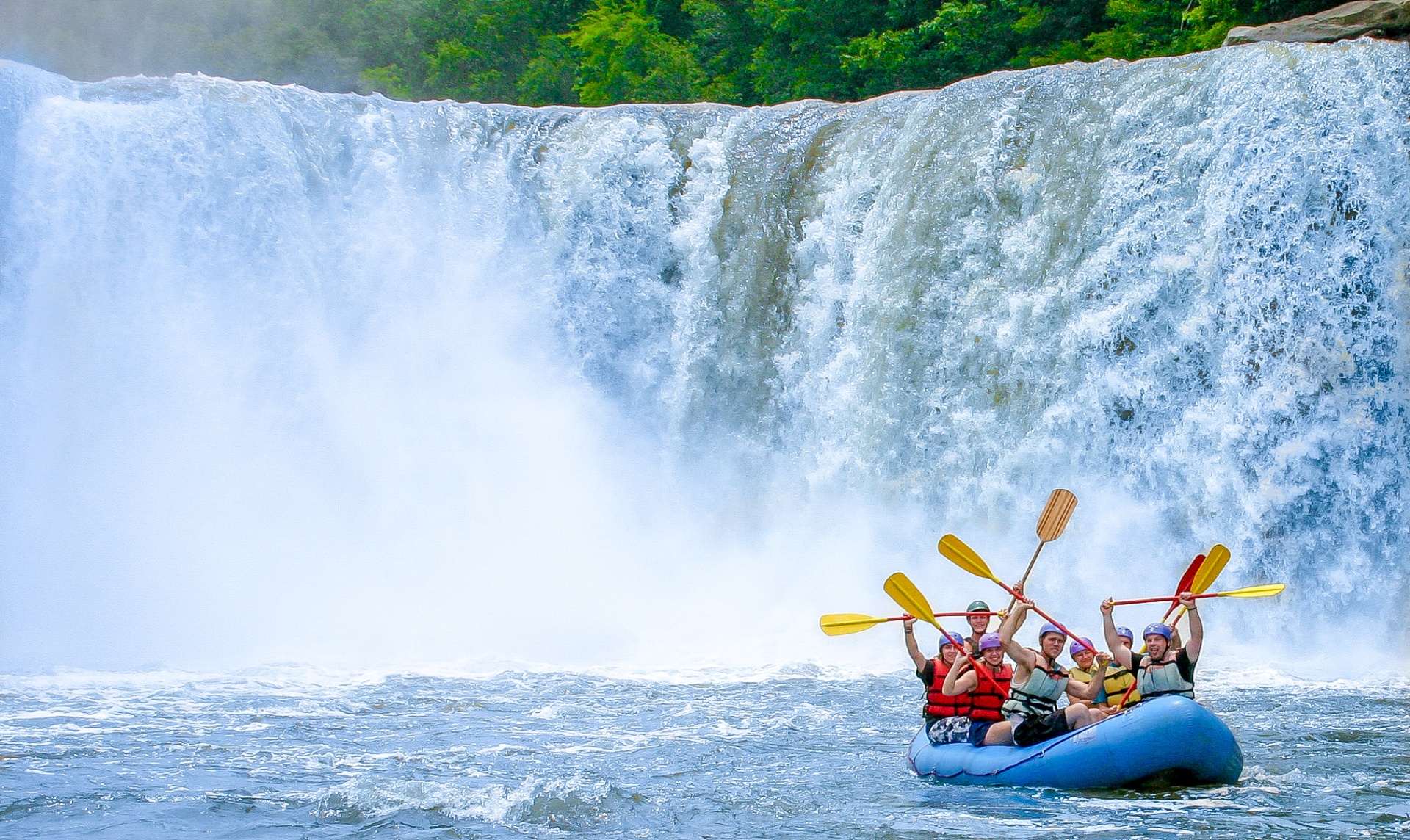 Raft team paddling beneath a thundering Kentucky waterfall