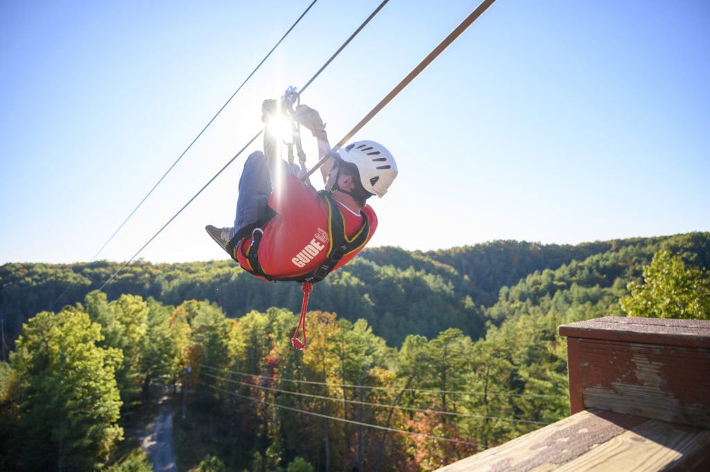 Zipline rider soaring over the Red River Gorge canopy